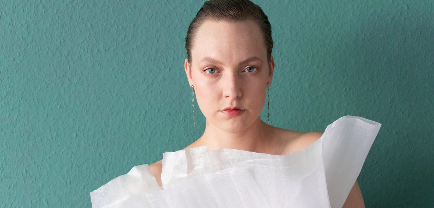 sustylery: Portrait Foto Frau mit Plastik-Verpackung als Kleidung